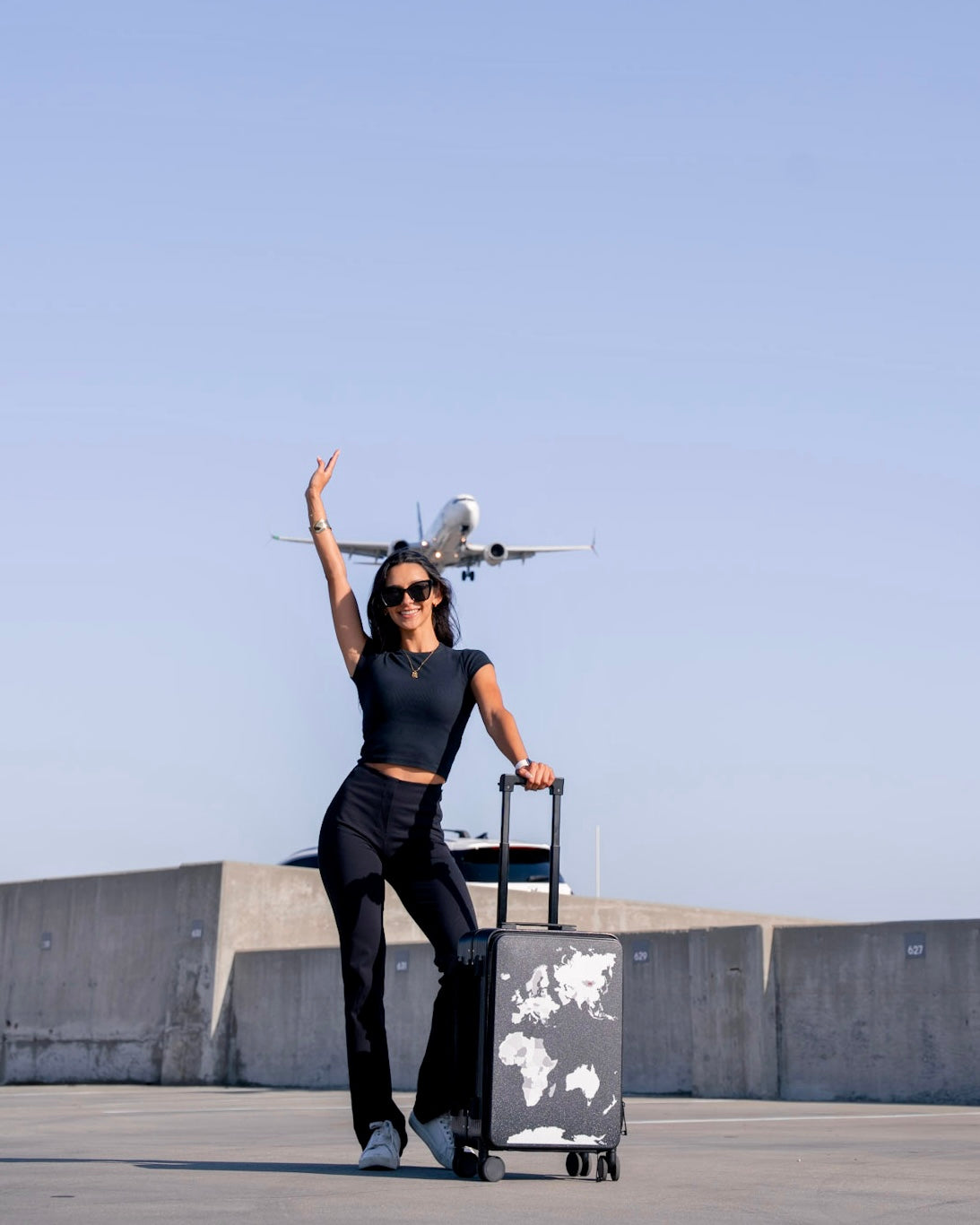Person with a suitcase and drone in an open area with a clear sky